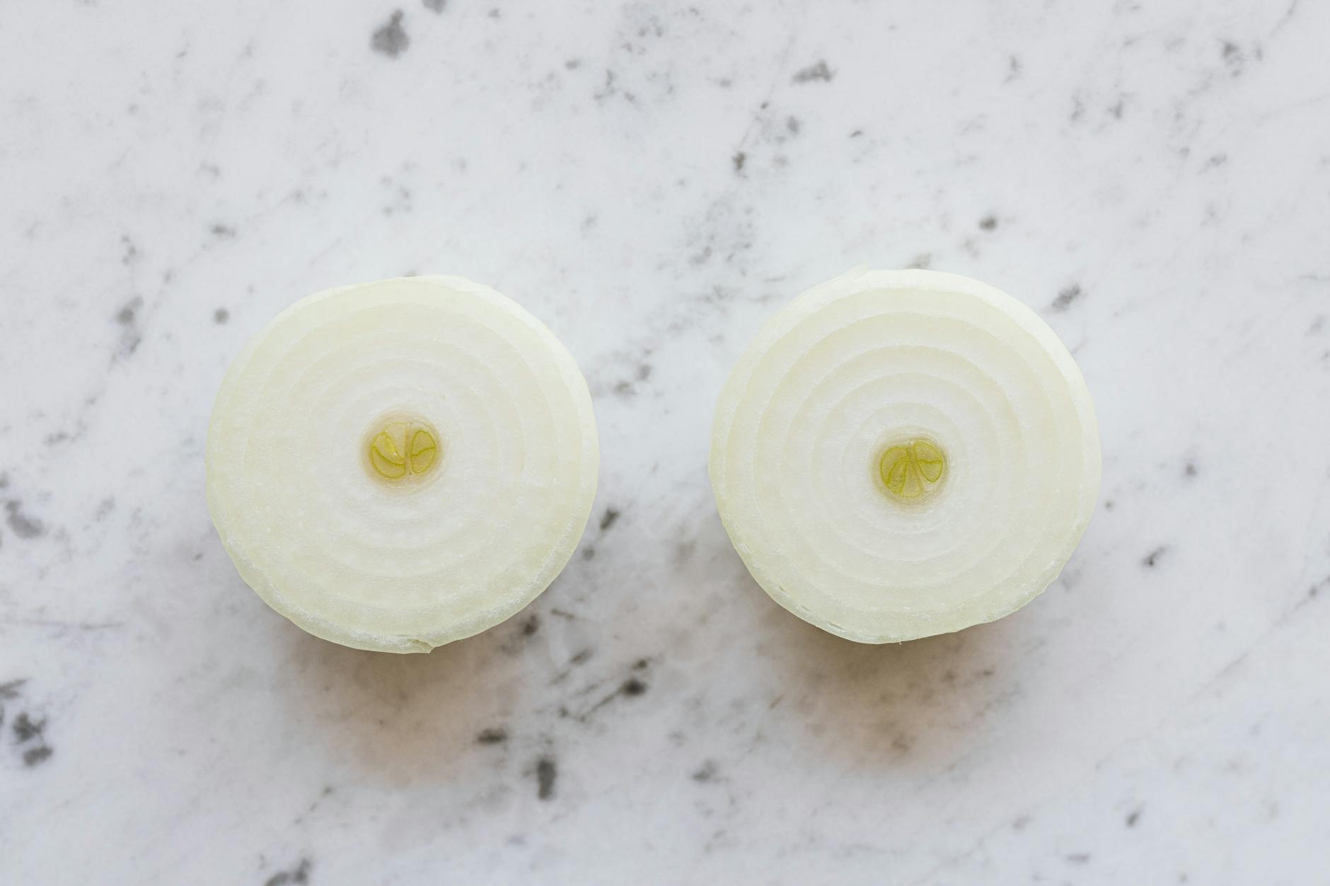yellow onion halves on marble table