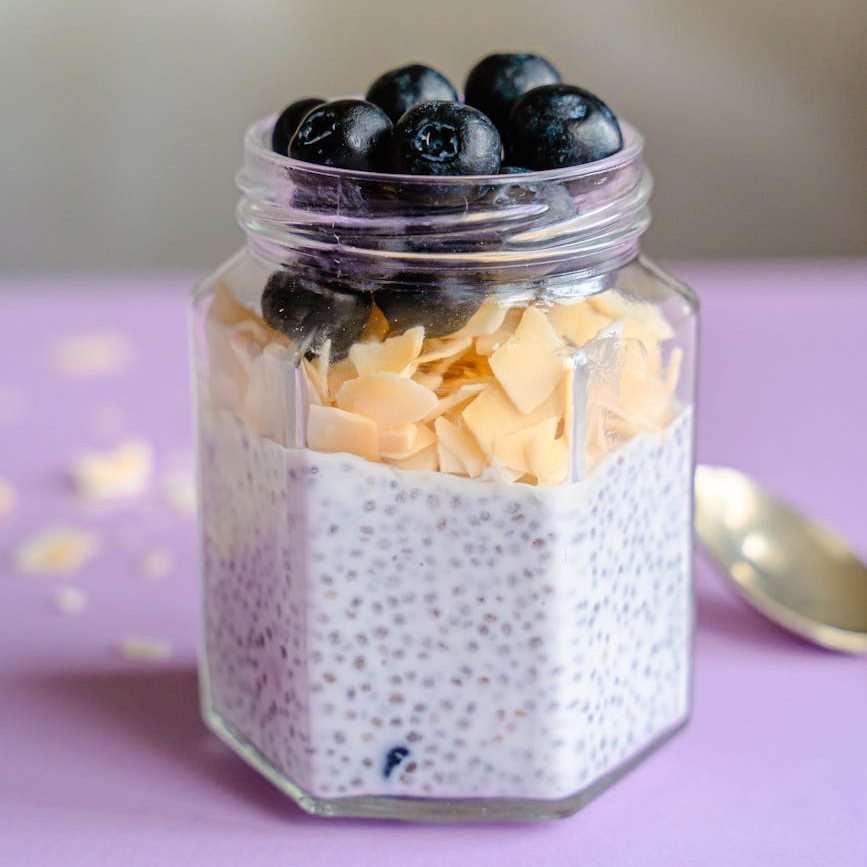chia seed pudding topped with almond flakes and blueberries in a jar